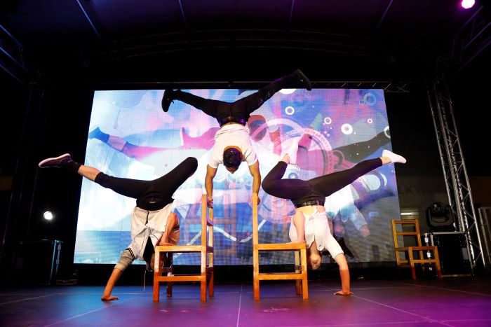 Three-Dancers-Performance-on-Staqe-Handstands-on-Chairs